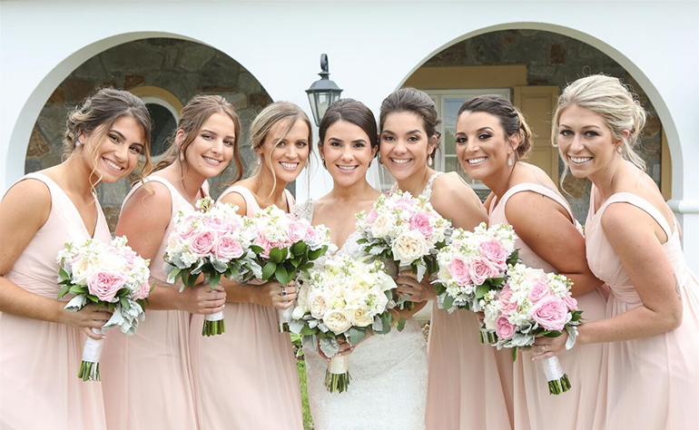 bride with bridesmaids holding bouquets